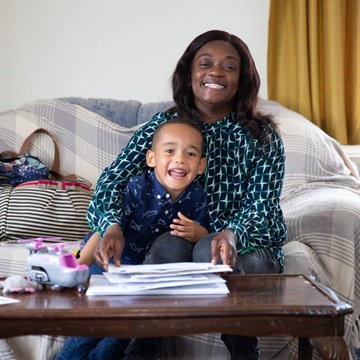 A mother and her son are both smiling on camera