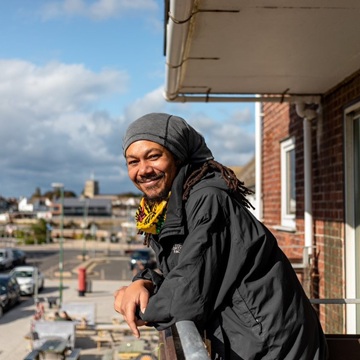 A man smiles from the balcony